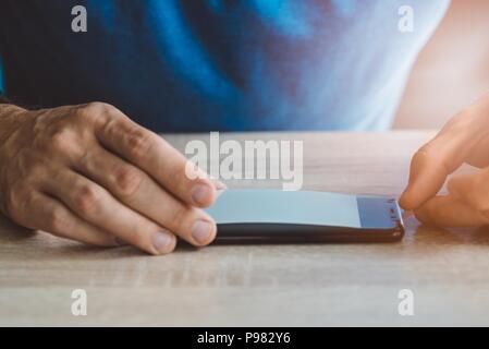 Man applying protective screen foil on his smartphone touchscreen Stock Photo