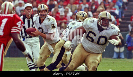 New Orleans Saints quarterback Bobby Hebert with his arm cocked back is  sacked by San Francisco 49ers defensive lineman Charles Haley during the  first quarter of their game at Candlestick Park in