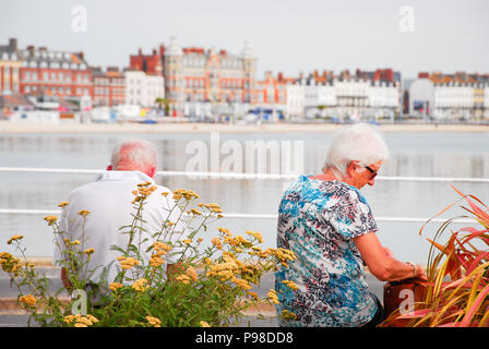 Weymouth. 16th July 2018. An older couple enjoy the early morning sunshine on Weymouth promenade Credit: stuart fretwell/Alamy Live News Stock Photo