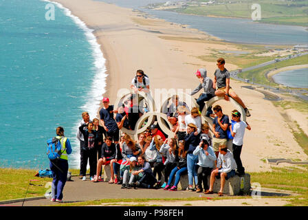 FILE PIC: Isle of Portland, UK. 16th July 2018. HISTORIC IMAGE, TAKEN 1st JULY 2016, which shows more than 30 youngsters, believed to be foreign language students, clambering on to the monument for a photograph/Isle of Portland, UK. 16th July 2018. The Portland stone 2012 Olympic rings at Portland Heights have been fenced off from the public, after visitors climbing onto the monument has left it weakened and liable to topple over Stock Photo