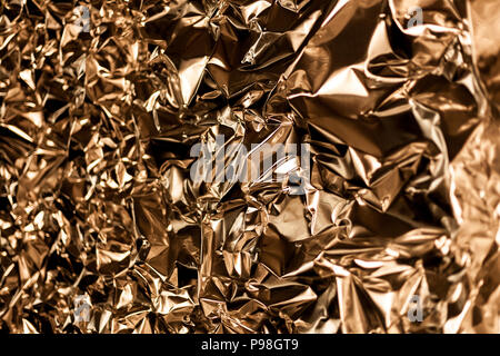 Full frame take of a sheeT of crumpled gold aluminum foil background Stock Photo