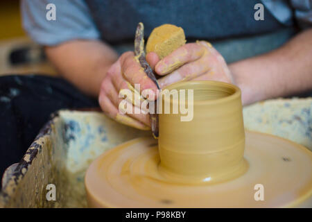 Professional male potter working with clay on potter's wheel Stock Photo