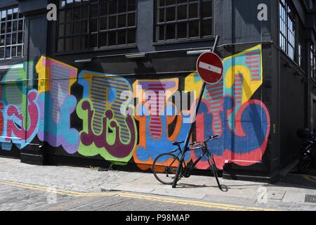 Bright coloured graffiti on black building Stock Photo