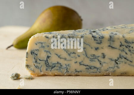 Piece of Gorgonzola picante cheese close up and a fresh ripe pear on the background for dessert Stock Photo