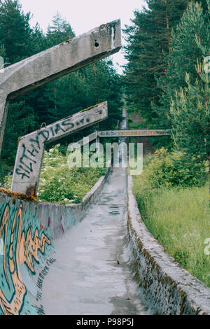 the now-disused concrete of the 1984 Sarajevo Olympic Bobsleigh and Luge Track curves through the forest, covered in graffiti Stock Photo