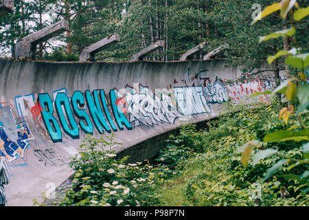 the now-disused concrete of the 1984 Sarajevo Olympic Bobsleigh and Luge Track curves through the forest, covered in graffiti Stock Photo