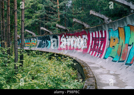 the now-disused concrete of the 1984 Sarajevo Olympic Bobsleigh and Luge Track curves through the forest, covered in graffiti Stock Photo