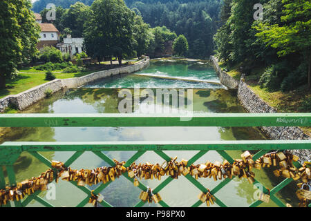 Countless small padlocks attached to a railing on a footbridge over the Pliva River, in the town of Jajce, Bosnia and Herzegovina Stock Photo