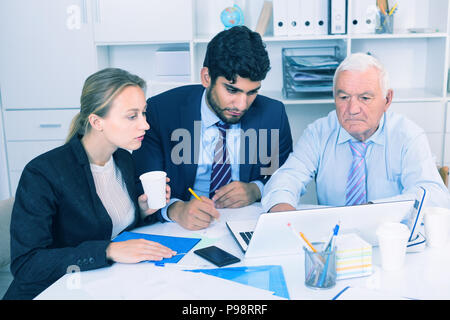 Managers are writing financial reports in the office. Stock Photo