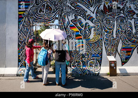 Berlin, Germany - july 2018: Group of tourists on sightseeing tour at the Berlin Wall / East Side Gallery in Berlin, Germany Stock Photo