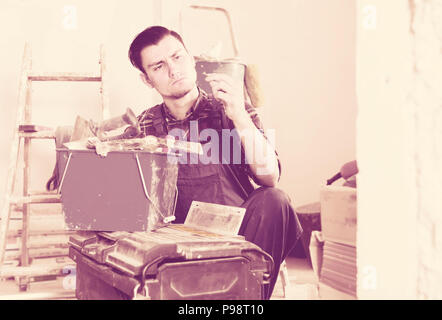 working builder handyman choosing necessary tool in toolbox Stock Photo