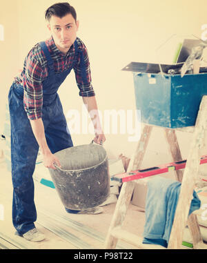 Worker repairing room and looking for necessary tool Stock Photo