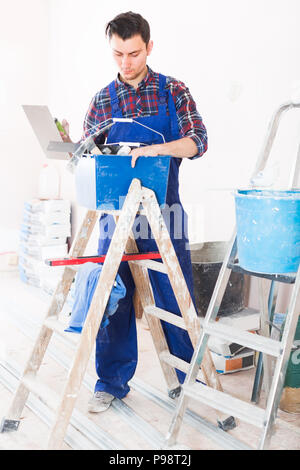 Young serious builder handyman choosing necessary tool in toolbox Stock Photo