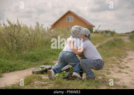 two brothers playiung outside and having a tumble Stock Photo