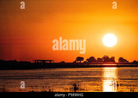 Sunset over the Namibian bank of the Chobe River, as seen from Botswana Stock Photo