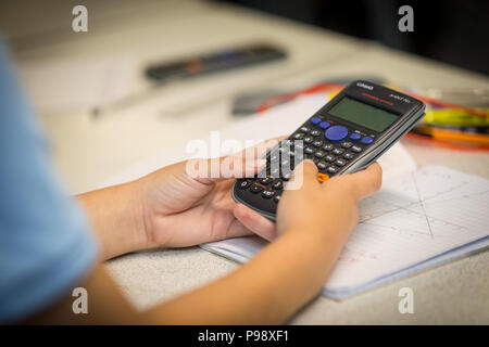 Secondary aged school pupil using an electronic calculator in a math lesson uk Stock Photo