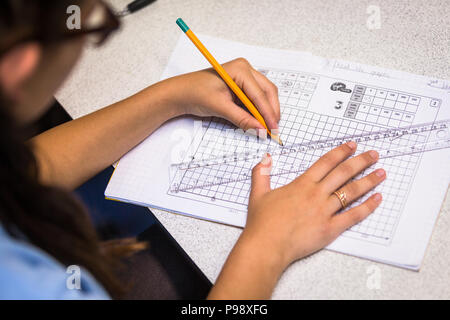 Secondary aged pupil drawing a graph in a maths lesson in school UK Stock Photo
