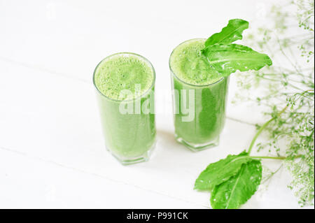 Blended green smoothie with ingredients or cocktail on white background, breakfast vegan with a place for your text, concept of raw food Stock Photo