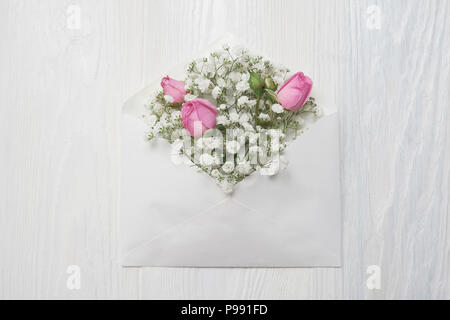 Mockup envelope with flowers and a letter, greeting card for Valentines Day of wedding with place for your text. Flat lay, top view photo mock up Stock Photo