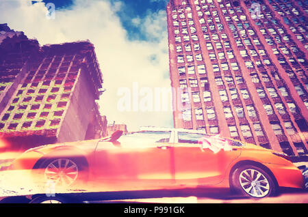 Distorted view of New York City yellow taxi reflected in a puddle, color toned picture, USA. Stock Photo