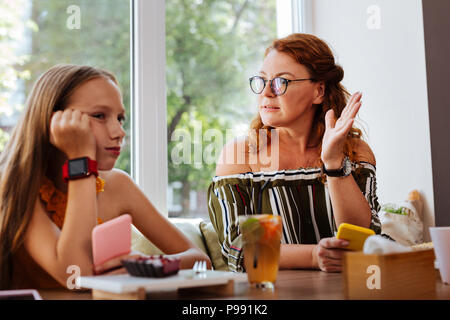 Serious mother wearing glasses having conflict with her daughter Stock Photo