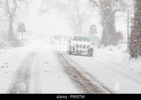 car number plate obscured by snow as it drives through thick falling snow in Scotland, UK Stock Photo