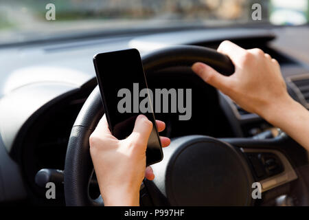 Woman using smartphone while driving the car - transportation and vehicle concept Stock Photo