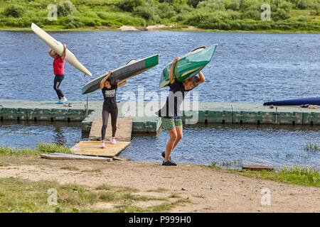 Polotsk, Belarus - July 6, 2018: After termination to rowing training, young athletes have got kayaks from water and carry them on coast on shoulders, Stock Photo