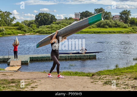 Polotsk, Belarus - July 6, 2018: Sportswomen come back from sports rowing training and bear canoe on shoulders. Stock Photo
