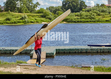 Polotsk, Belarus - July 6, 2018: One teen girl carrying their canoes on their shoulders after kayak slalom. Stock Photo