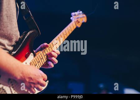 Young Man Plays an Electric Guitar on Stage Stock Photo