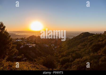 Smoggy orange sunrise view from Runyon Canyon Park towards Hollywood and Downtown Los Angeles, California. Stock Photo