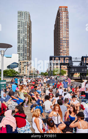 New York City, USA - July 4, 2018: People wait to watch Fourth of July Independence Day fireworks at a Long Island pier.