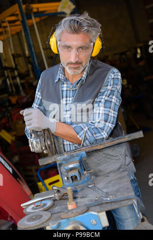 Portrait of man using angle grinder Stock Photo