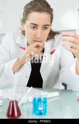 seriously looking female doctor with blood probe and request form Stock Photo