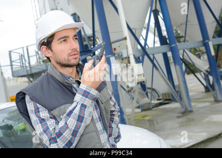 Man in cement factory using walkie talkie Stock Photo