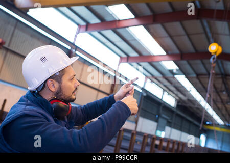 construction worker with helmet in warehouse Stock Photo
