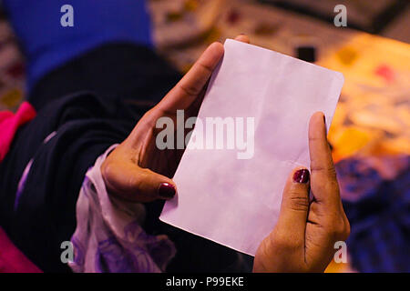 Woman hands holding and reading blank paper sheet or letter, closeup shot Stock Photo