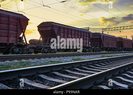 railcar for dry cargo during beautiful sunset and colorful sky, railroad infrastructure, transportation and industrial concept Stock Photo