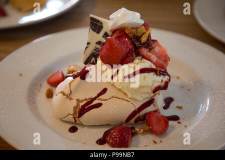 Strawberries and cream meringue fancy desert on white plate Stock Photo