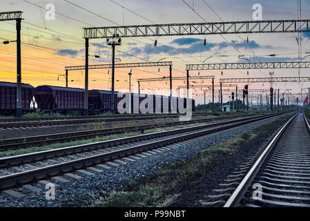 railcar for dry cargo during beautiful sunset and colorful sky, railroad infrastructure, transportation and industrial concept Stock Photo