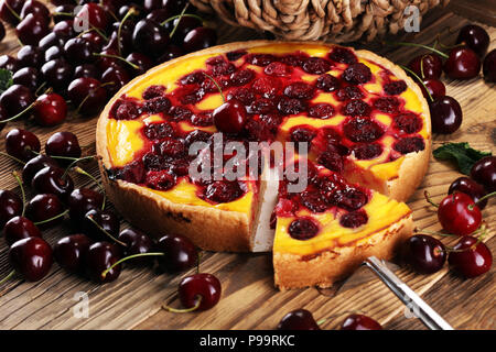 cherry cake and a bunch of cherries on table. Stock Photo