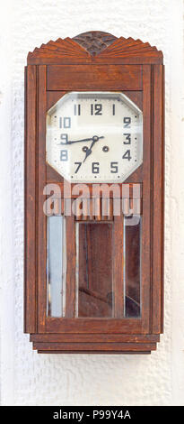 Wooden grandfather clock with pendulum at wall Stock Photo