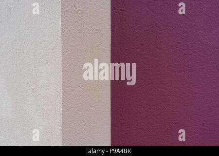 The angle of the beige and magenta-colored wall of the building with the texture Stock Photo