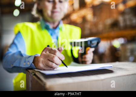 Warehouse woman worker with barcode scanner. Stock Photo