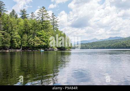 Female kayaker on a remote pond in the Adirondack wilderness Stock Photo