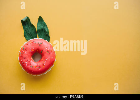 A creative donut with ears of leaves resembling a rabbit on a yellow background in a minimal style. Stock Photo