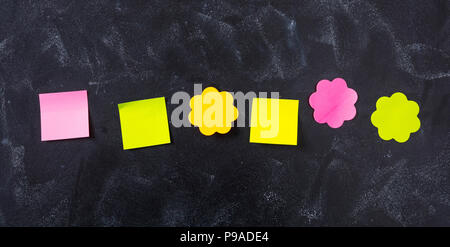 School concept. Six colorful notes in various shapes with copy space on blackboard background. Stock Photo