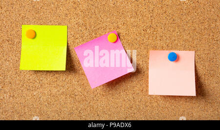School concept. Three colorful sticky notes with pushpins and blank space, isolated on cork background, Stock Photo