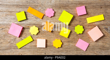 School concept. Sticky colorful notes in various shapes isolated with copy space on wooden background. Stock Photo